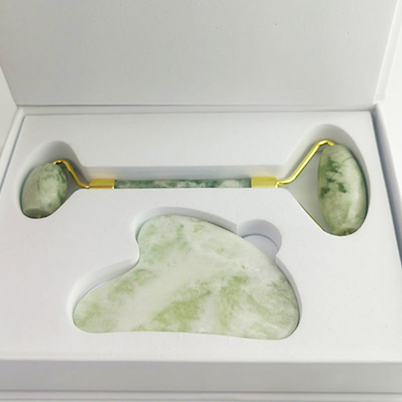 White jade gua sha board in use along jawline contour