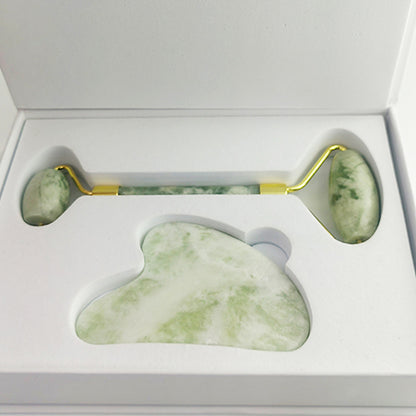 White jade gua sha board in use along jawline contour